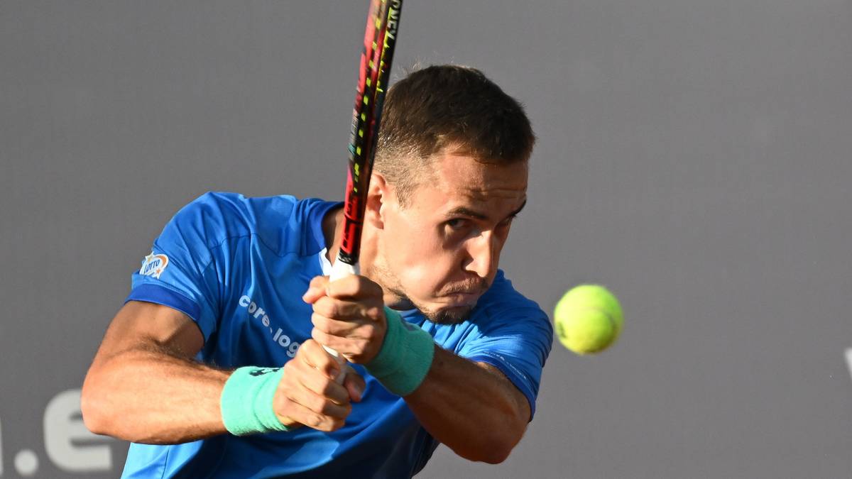 Tenisista Daniel Michalski w akcji, uderzający piłkę rakietą.