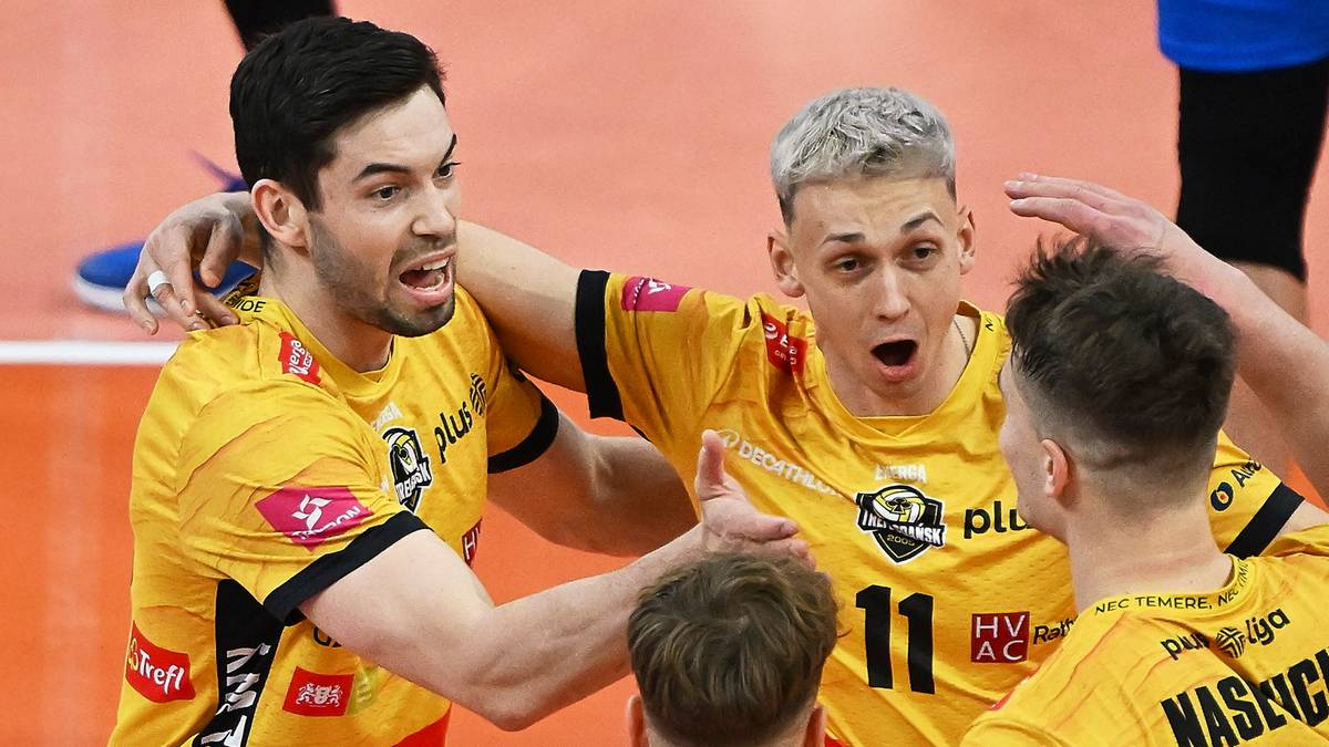 Trzech siatkarzy w żółtych strojach sportowych podczas meczu.