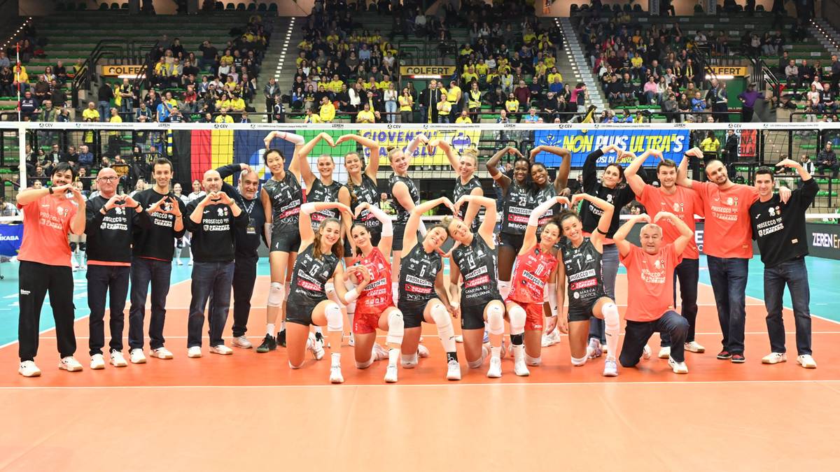 Siatkarki Imoco Volley świętują zwycięstwo w Pucharze Włoch, pozując z pucharem na tle trybun.