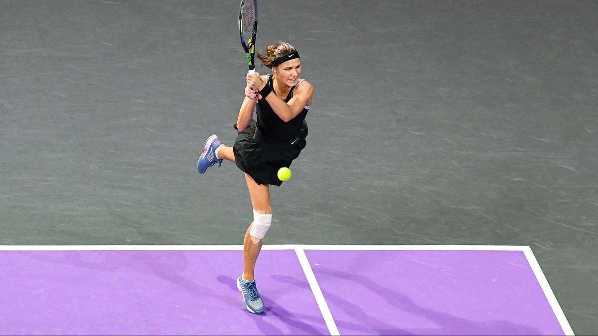 Kobieta grająca w tenisa, odbija piłkę rakietą podczas meczu na korcie.