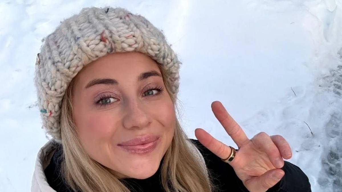 Kobieta w czapce zimowej pokazuje znak pokoju.