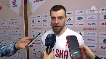 Mężczyzna w białej koszulce reprezentacji Polski udziela wywiadu przed mikrofonem.