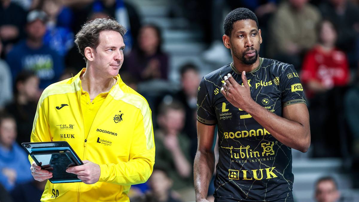 Dw&oacute;ch siatkarzy na boisku, jeden w ż&oacute;łtej kurtce, drugi w czarnej koszulce drużynowej.