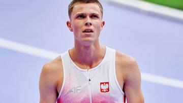 Mateusz Wyderka w stroju sportowym z godłem Polski, patrzący w bok podczas zawod&oacute;w lekkoatletycznych.
