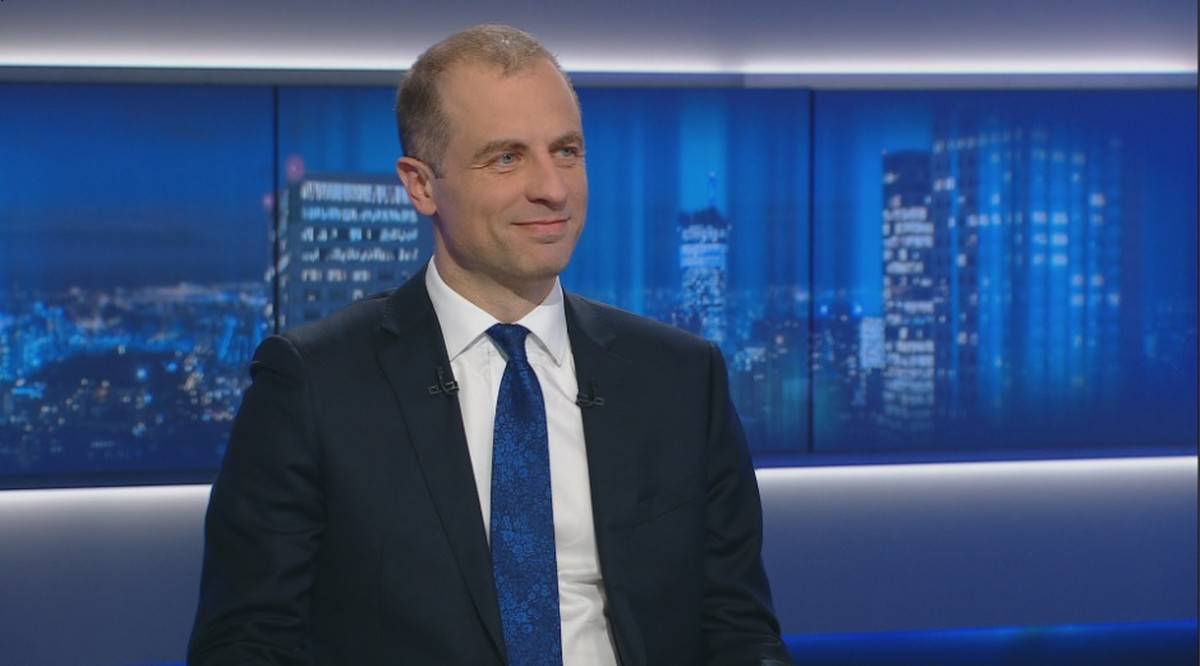 Profesor Grzegorz Kołodko w studiu telewizyjnym, ubrany w garnitur i krawat.