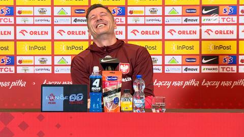Robert Lewandowski śmieje się na tle ścianki sponsorskiej z logo Polski i sponsor&oacute;w.
