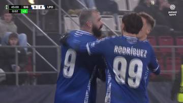 Piłkarze Lecha Poznań świętujący zdobytego gola. Dwóch zawodników w niebieskich koszulkach z numerami 9 i 99 obejmuje się w geście radości.