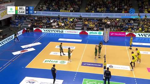 Mecz siatkówki - zawodnicy na boisku, publiczność na trybunach, tablica wyników.