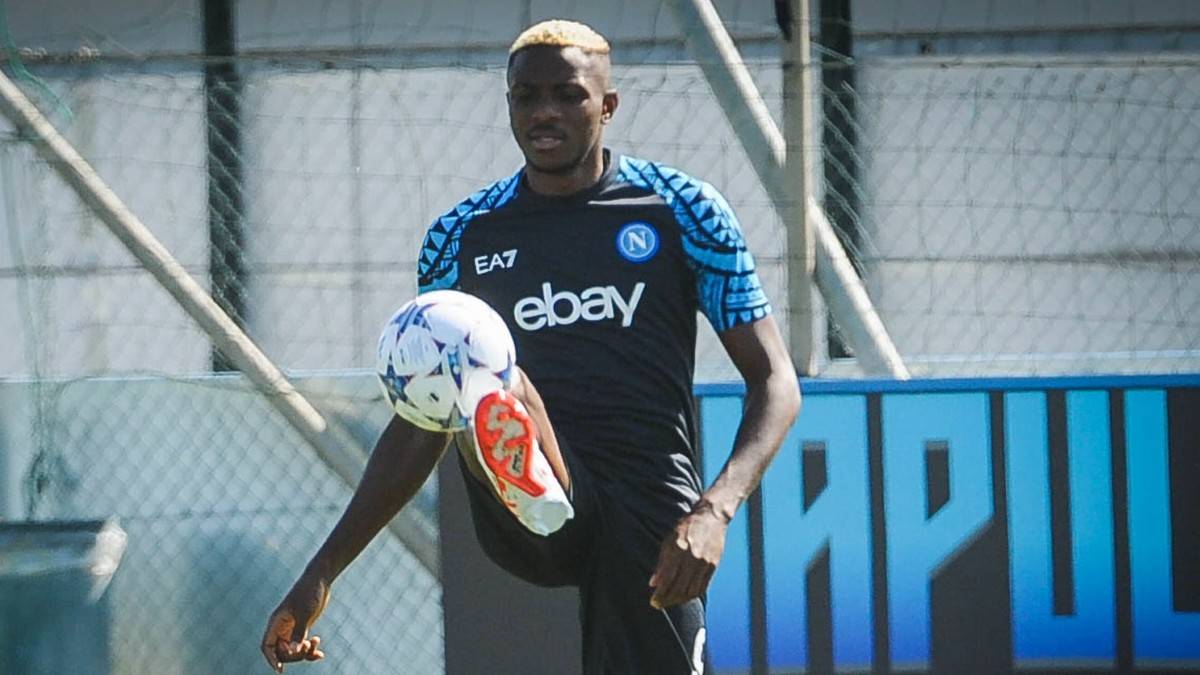 Victor Osimhen w koszulce Napoli z logo EA7 i eBay ćwiczy z piłką.