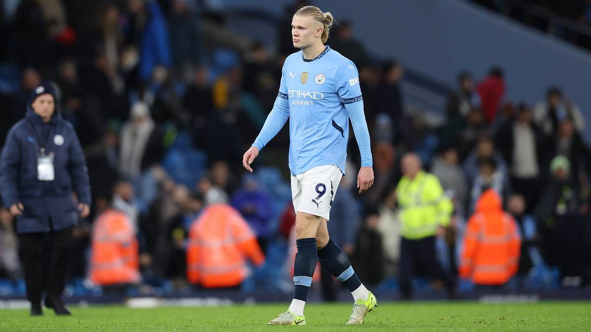 Piłkarz Erling Haaland w błękitnej koszulce Manchesteru City z numerem 9 na plecach, stojący na boisku piłkarskim.