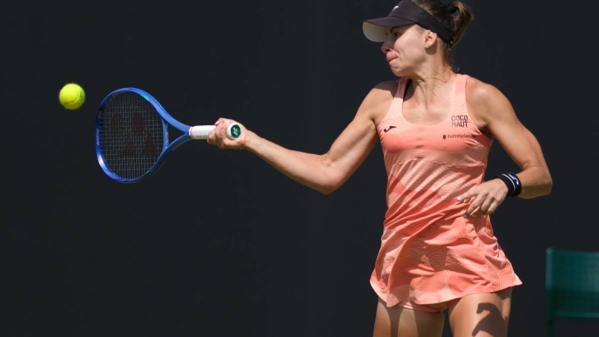 Tenisistka Magdalena Linette uderza piłkę rakietą podczas meczu.