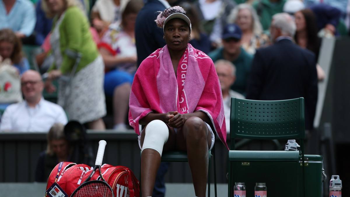 Venus Williams siedząca na krześle z różowym ręcznikiem na ramionach.