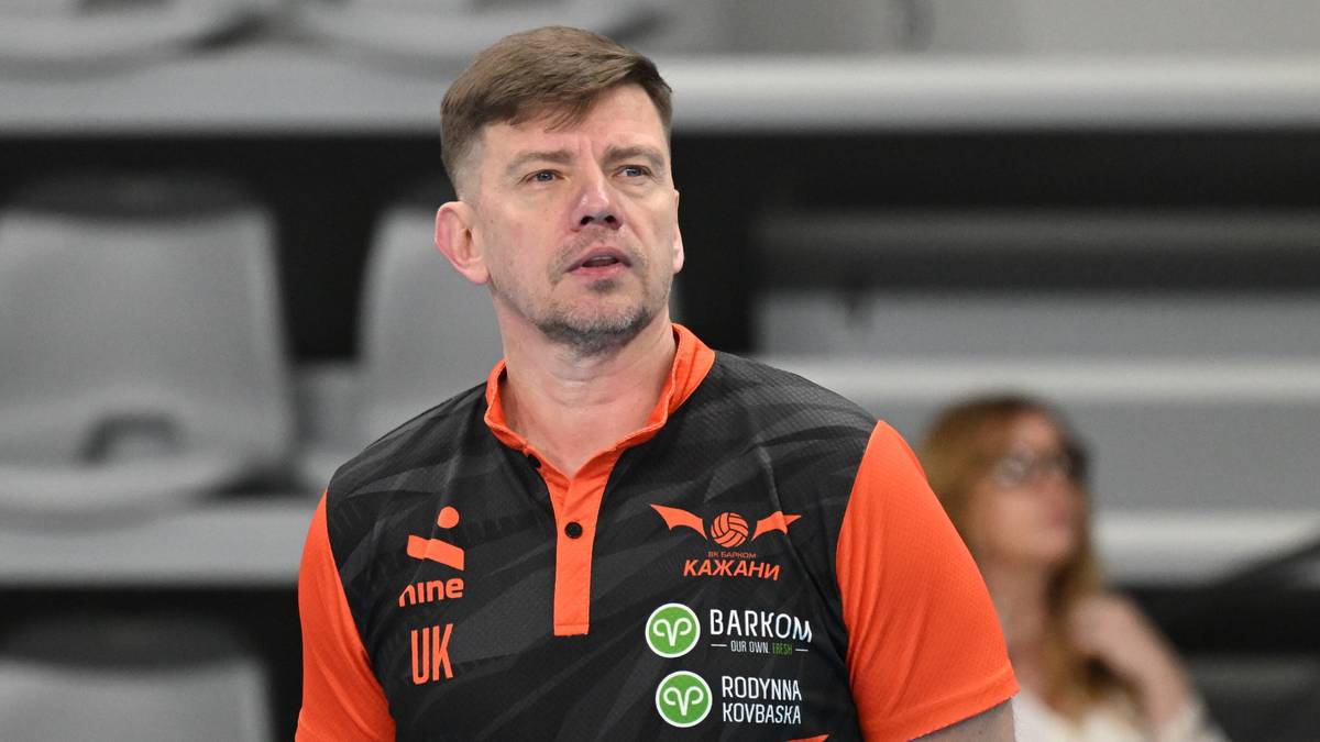 Mężczyzna w kamizelce sportowej z logotypami drużyny siatkarskiej.