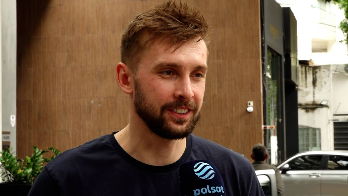 Portret Mateusza Bieńka, siatkarza reprezentacji Polski, z bliska. Ma krótkie, brązowe włosy i zarost. Na jego koszulce widoczne jest logo Polsatu.