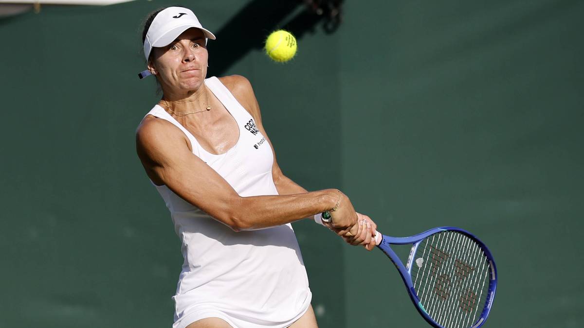 Magda Linette uderza piłkę rakietą tenisową.