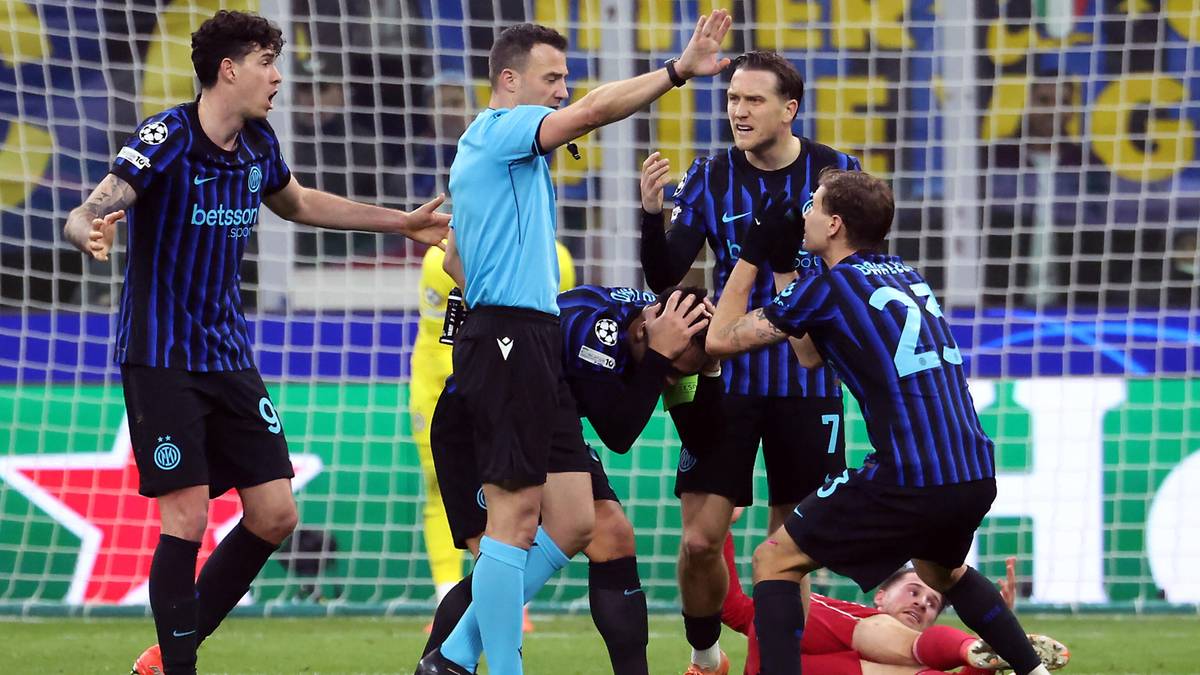 Piłkarze Interu Mediolan otaczają sędziego, jeden z nich leży na ziemi po faulu.