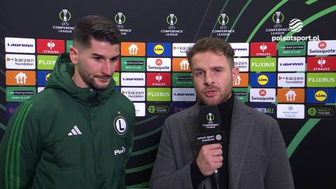 Piłkarz Antonio Colak w zielonej kurtce stoi obok dziennikarza zadającego mu pytanie.