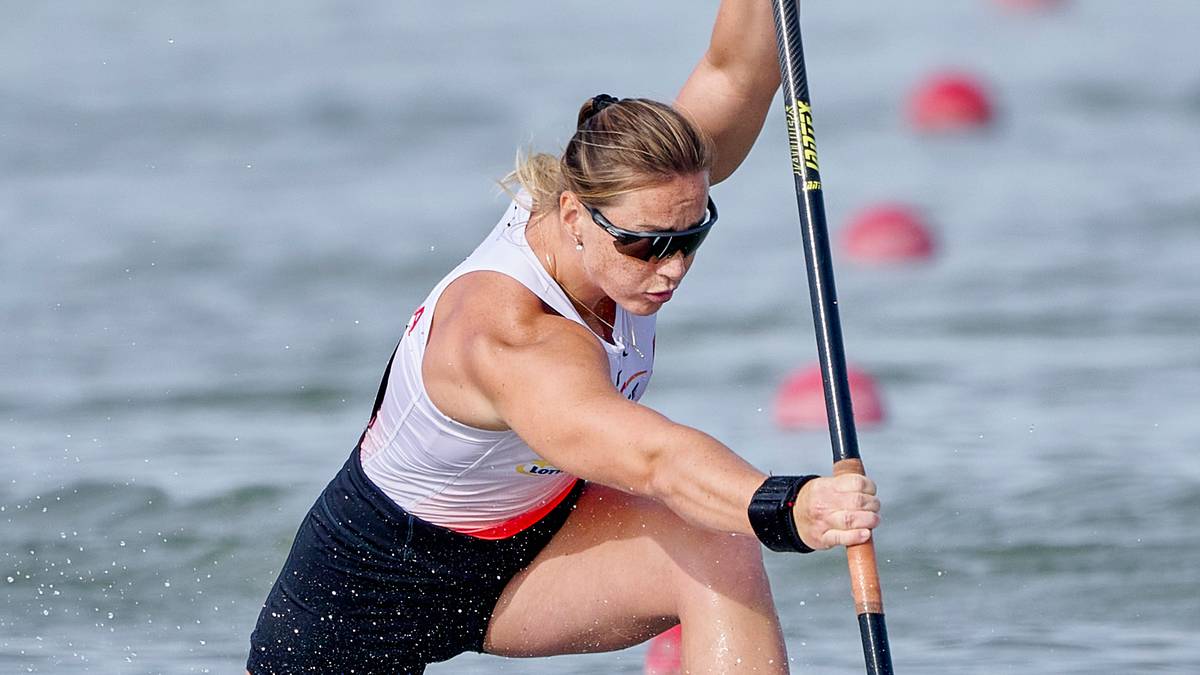 Kobieta wiosłująca w kajaku podczas zawodów sportowych.
