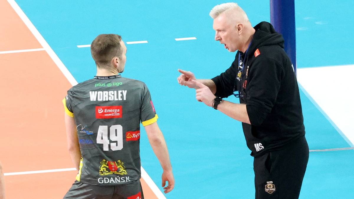 Siatkarz Joe Worsley w stroju sportowym stojący tyłem do widza, rozmawiający z trenerem.