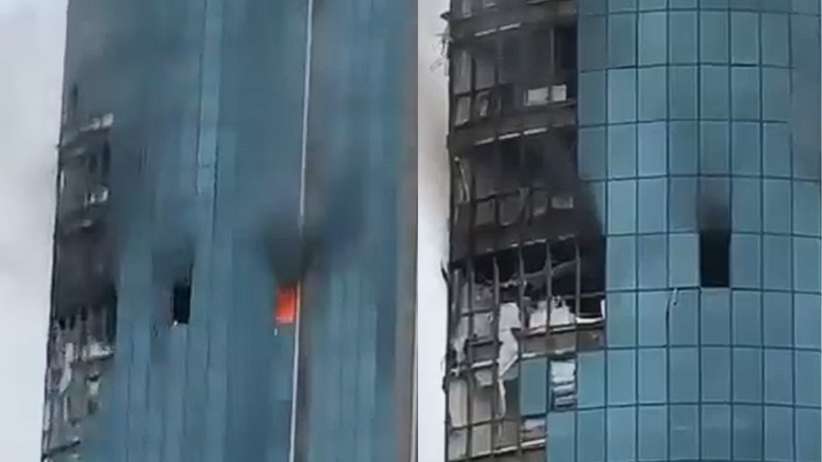 Uszkodzony ogniem i dymem wieżowiec Grozny-City w Groznym, z widocznymi wypalonymi oknami i fragmentami fasady.