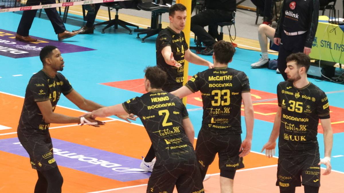 Siatkarze ZAKSA Kędzierzyn-Koźle w czarnych strojach z żółtymi numerami na boisku.