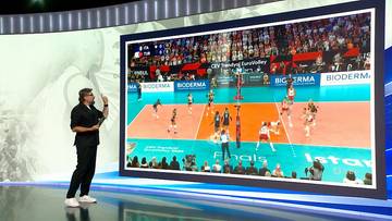 Jakub Bednaruk w studio telewizyjnym analizuje finałowy mecz siatkarek pomiędzy Włochami a Turcją na dużym ekranie.