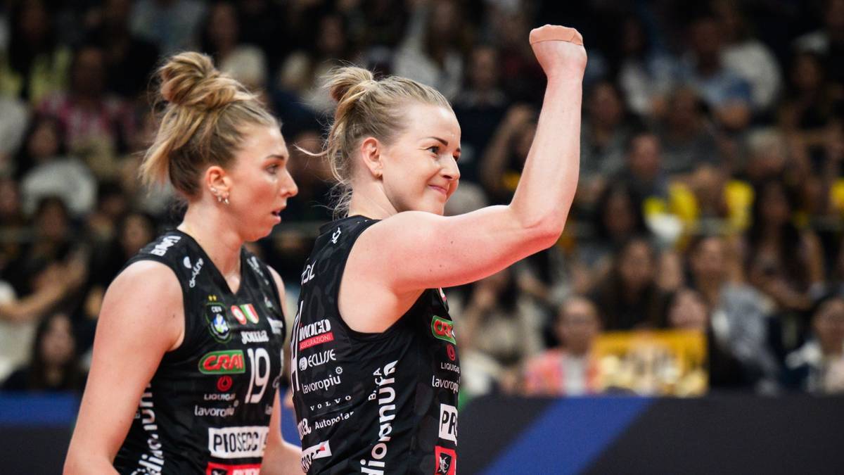 Dwie siatkarki w czarnych strojach sportowych świętują sukces na boisku.