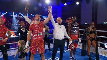 Sędzia ringowy unosi rękę zwycięskiego Pawła Stępnia w ringu podczas gali Sheraton Boxing Night