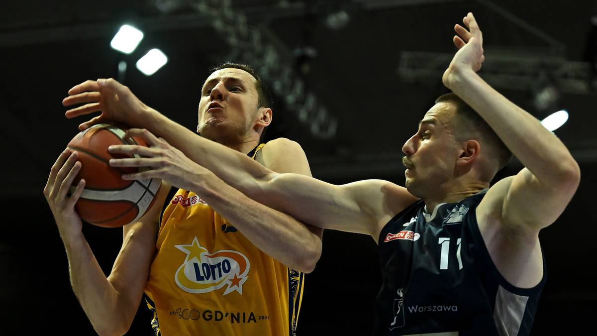 Dw&oacute;ch koszykarzy walczy o piłkę podczas meczu. Zawodnik w ż&oacute;łtej koszulce z napisem "LOTTO GDYNIA" trzyma piłkę, a zawodnik w czarnej koszulce z numerem 71 stara się mu ją odebrać.