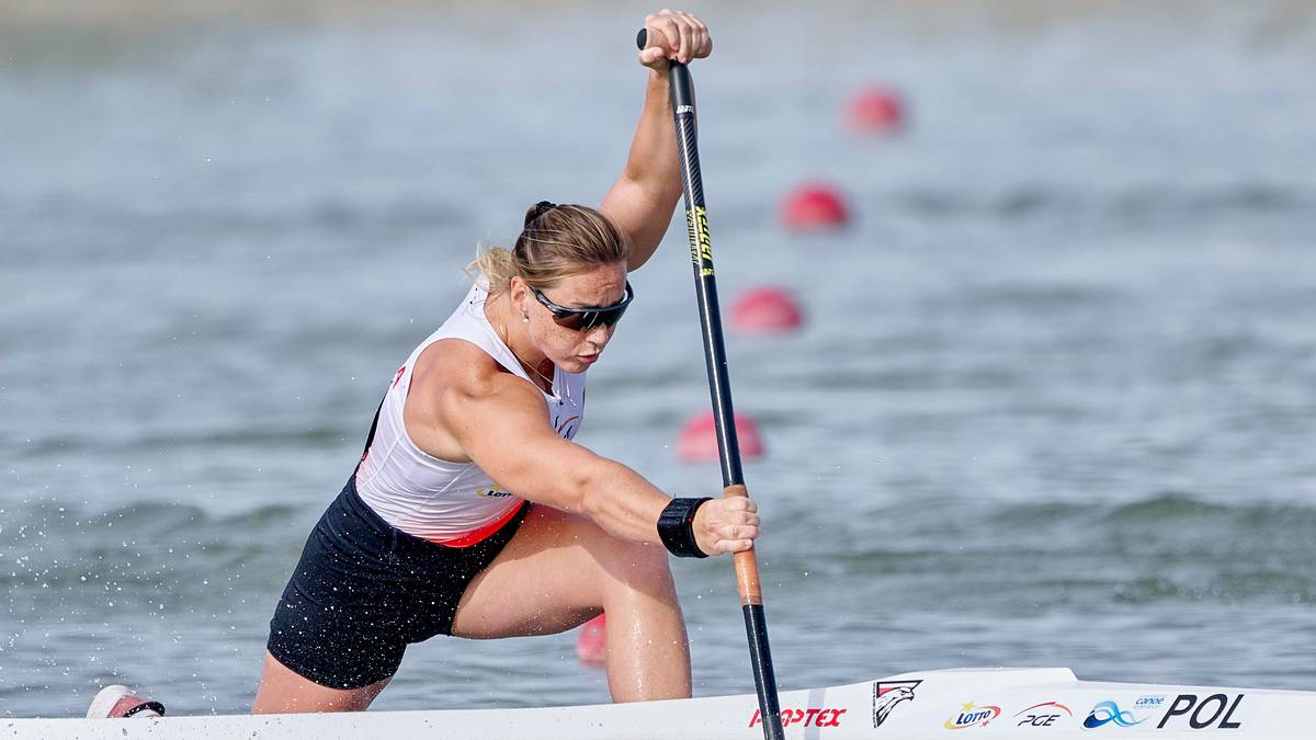 Kobieta wiosłująca w kajaku na zawodach sportowych.
