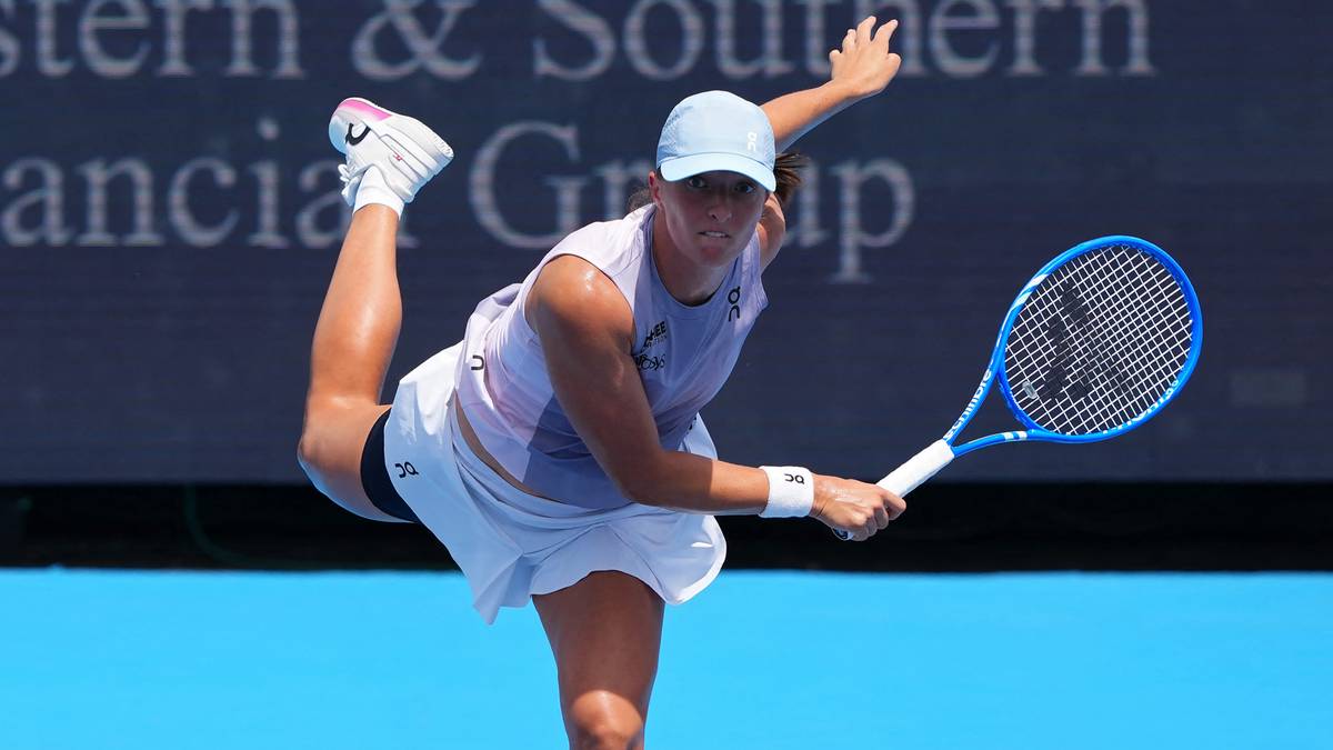 Iga Świątek wykonuje serwis podczas meczu tenisowego.