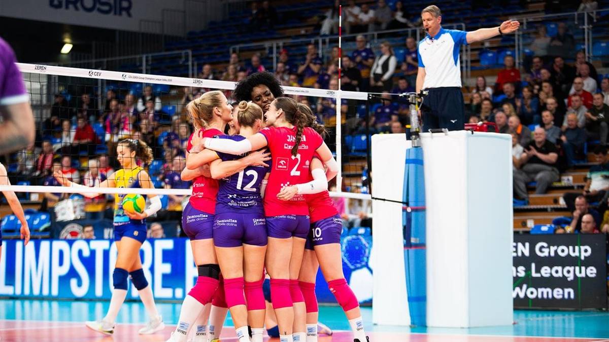 Siatkarki DevelopResu Rzeszów w fioletowych strojach przytulają się na boisku po wygranym meczu.