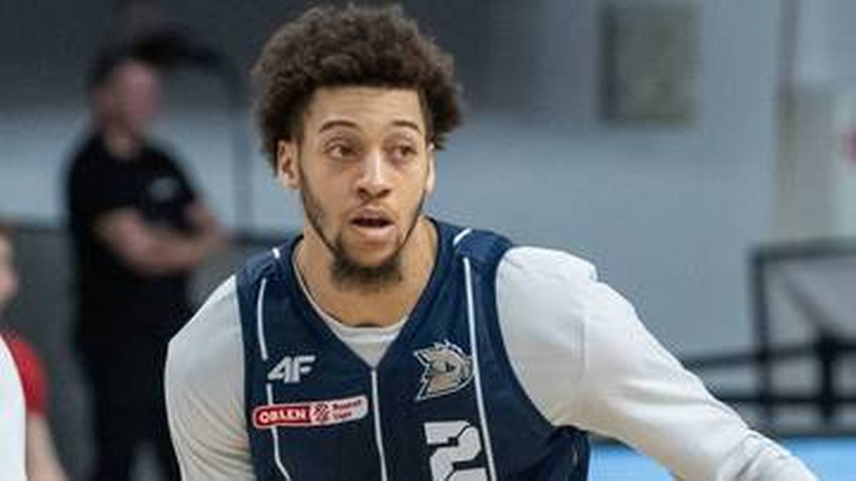 Koszykarz w niebiesko-białym stroju z logo drużyny, z wyrazem skupienia na twarzy.