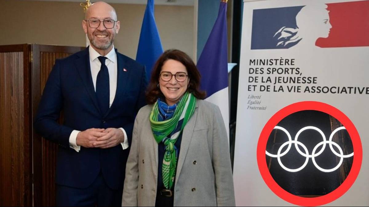 Mężczyzna i kobieta stoją przed flagami i logo.