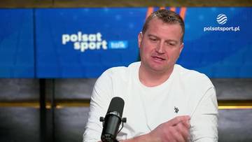 Mężczyzna w białej koszulce siedzi przed mikrofonem. W tle widać niebieski ekran z logo "polsat sport talk" oraz "polsatsport.pl".