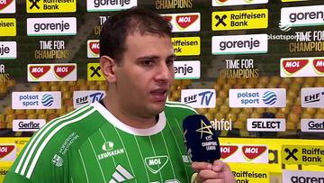 Dejan Milosavljev w zielonym stroju sportowym udziela wywiadu na tle ścianki sponsorów.