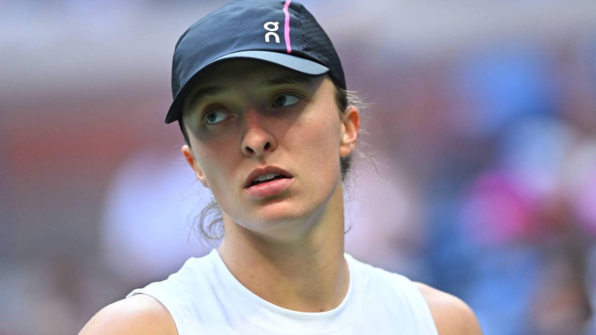 Portret Igi Świątek w czapce z daszkiem i białej koszulce sportowej.