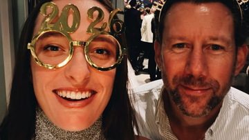 Kobieta i mężczyzna pozują do zdjęcia w okularach z napisem "2020" i "Happy New Year". W tle widać fajerwerki.