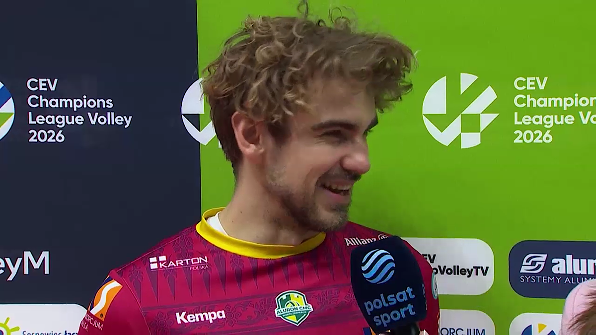 Uśmiechnięty siatkarz z kręconymi włosami w stroju sportowym.