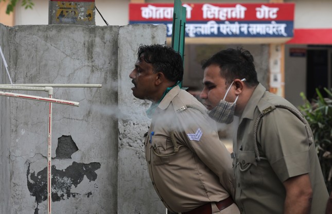 Indyjski personel policji wdycha parę ziołową wydobywającą się z rur jako środek zapobiegawczy przeciwko COVID-19 