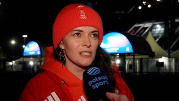 Kobieta w czerwonej czapce i bluzie z kapturem, mówiąca do mikrofonu Polsat Sport.