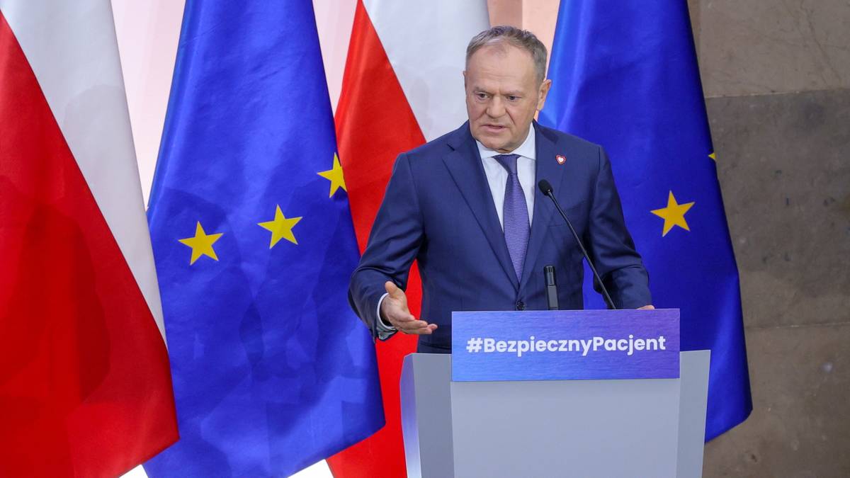 Donald Tusk przemawia na szczycie medycznym, stojąc za mównicą.