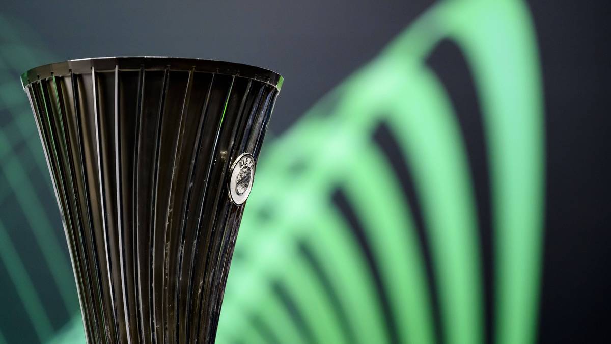 Puchar Ligi Europy UEFA, ciemny metalowy puchar z żłobieniami, na tle rozmytego zielonego tła.