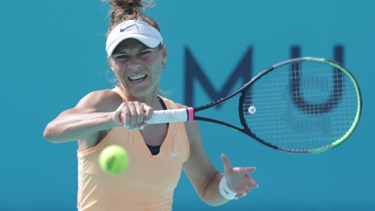 Tenisistka wykonuje uderzenie forhendowe podczas meczu.