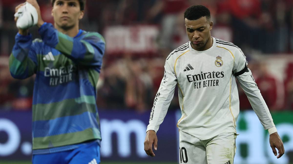 Dw&oacute;ch piłkarzy na boisku, jeden w białej koszulce Realu Madryt z numerem 10, drugi w niebiesko-zielonej koszulce.