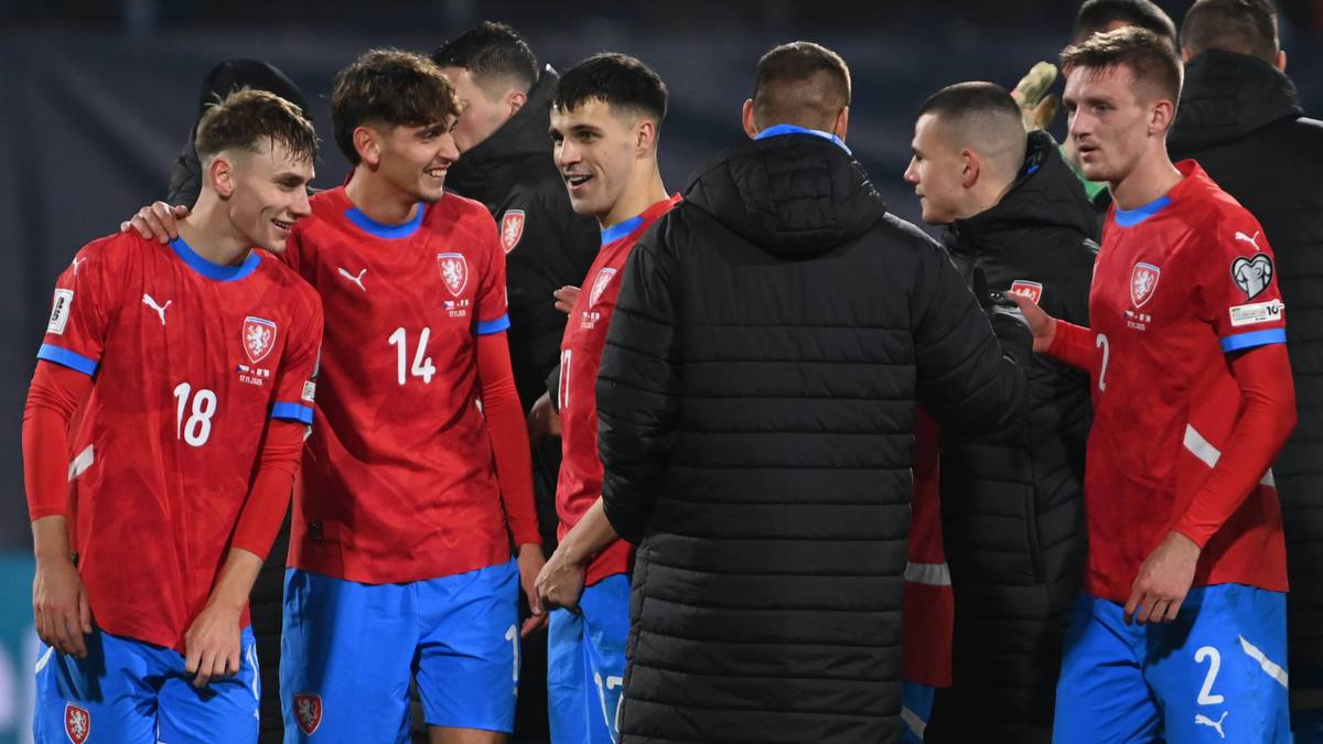 Piłkarze reprezentacji Czech stoją w kręgu na boisku.