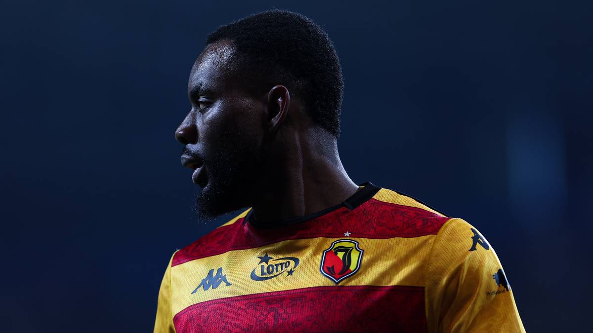 Piłkarz Jagiellonii Białystok w żółto-czerwonej koszulce z widocznym logo Superbet.