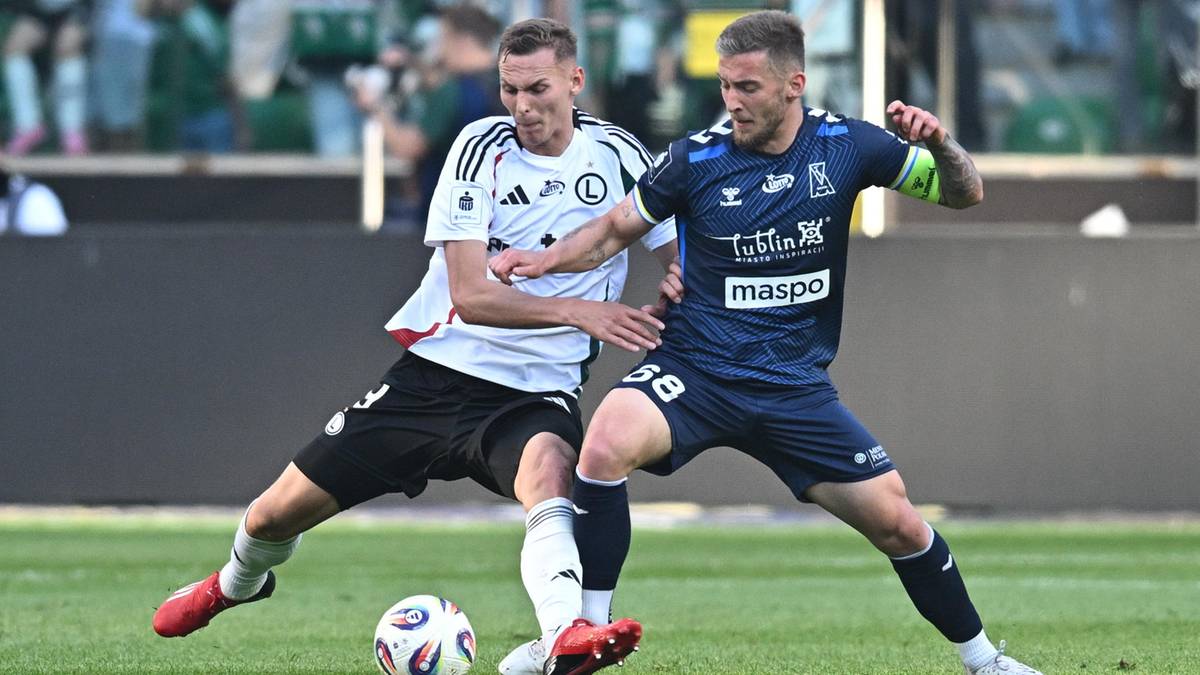 Dw&oacute;ch piłkarzy rywalizuje o posiadanie piłki na boisku.
