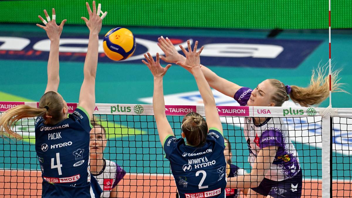 Siatkarka w akcji podczas meczu, próbuje zablokować piłkę.