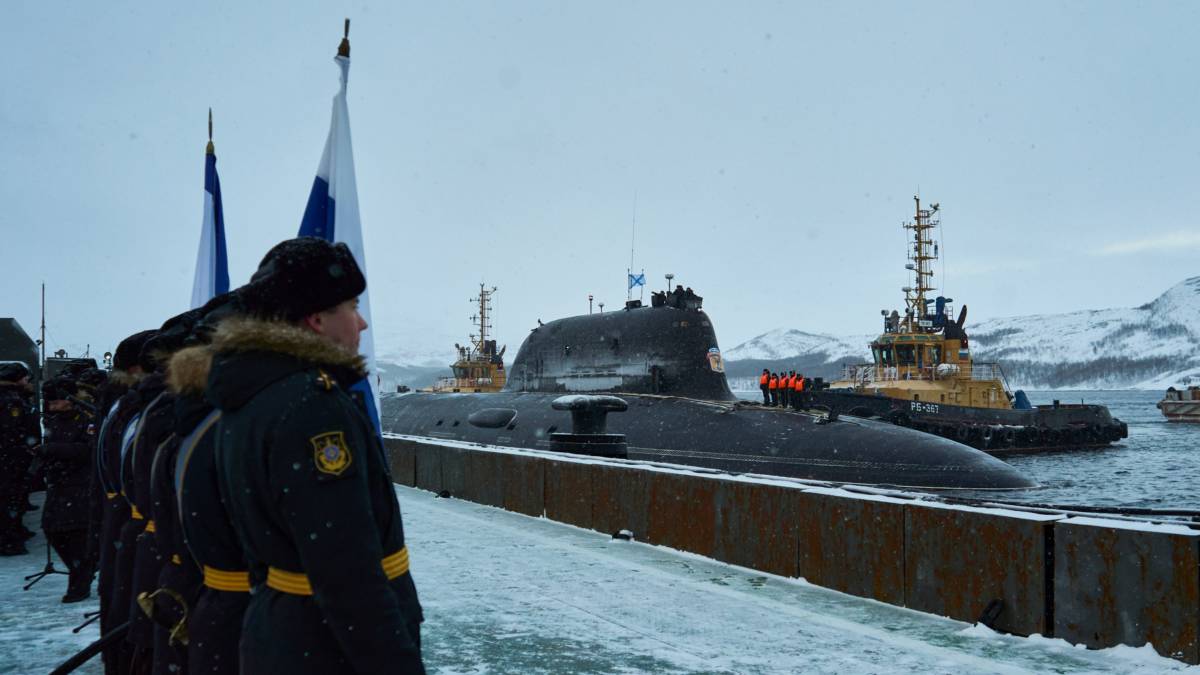 Okręt podwodny zacumowany przy nabrzeżu w zimowym krajobrazie Arktyki.
